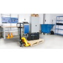 Wózek paletowy PL 2000 D3 Quicklift - ustawiony z paletą i akumulatorem w warsztacie
