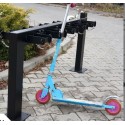 Stojak na hulajnogi elektryczne - hulajnoga zawieszona na stojaku przy chodniku