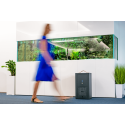 Sterylizator Sterylis Pure Air Smart - urządzenie w biurze przy akwarium, obok przechodzi kobieta