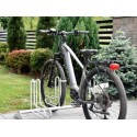 Stojak na rowery RAD-5 Premium - rower elektryczny w stojaku na tle ogrodu