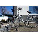 Stojak na rowery CROSS-3 inox - rower zaparkowany w stojaku na chodniku